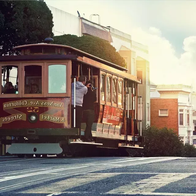 A cable car rounds a hill 在贝博体彩app with passengers looking out the window.